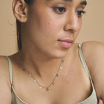 Dual tone necklace with small dangling heart charms in silver and rose gold tones on a fine chain