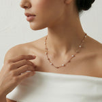 Rose gold beaded chain necklace with evenly spaced pearl accents on a minimal