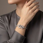 Infinity knot crystal cuff bracelet with sleek open design and sparkling stone detailing on a minimal silver finish