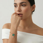Rose gold chain bracelet with emerald green flower charm and teardrop crystal pendant