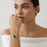 Minimal black enamel oval bracelet with sparkling crystal accents and delicate chain design for women.