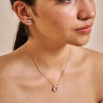 Rose gold halo pendant necklace with sparkling crystal circle charm on a delicate chain against