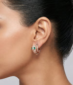 Rose gold serpent hoop earrings with emerald green stones and crystal detailing for women’s luxury jewellery styling.