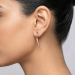 Minimal rose gold wave stud earrings with sleek sculptural curved design and polished finish