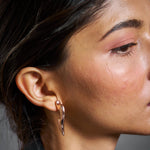 Minimal rose gold wave stud earrings with sleek sculptural curved design and polished finish