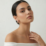 Rose gold wave hoop earrings with sparkling crystal detailing and modern curved design