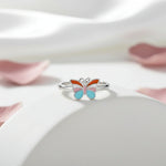 Colourful pastel butterfly adjustable ring with pink blue orange and white enamel detailing on a silver finish band.