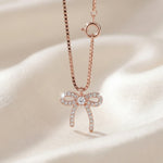 Rose gold crystal bow charm with chain link design for bracelet or watch charm styling.