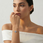 Elegant silver bracelet with blue sapphire stones and crystal charm centrepiece on a delicate chain design.