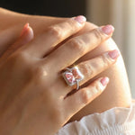 Luxury blush pink and peach crystal halo ring with square stones and sparkling designer band for women.