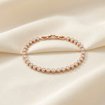 Rose gold crystal tennis bracelet with round bezel-set stones and elegant luxury design for women.