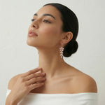 Elegant rose bloom crystal drop earrings with soft pink floral design and sparkling dangling stones in rose gold tone.