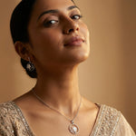 Moonlit floral circle jewelry set with matching pendant necklace and hoop earrings featuring white flower charms and crystal accents.