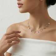 Two tone chain necklace with small dangling heart and drop charms evenly spaced, minimal elegant design