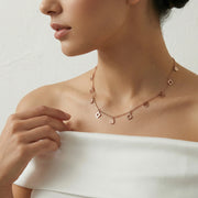 Rose gold necklace with delicate dangling charms and minimal drop design on a fine chain