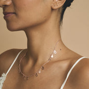 Rose gold necklace with dangling teardrop charms on a fine chain, minimal elegant design for everyday wear