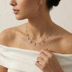 Dual tone charm chain necklace with small geometric and teardrop dangling charms on a delicate chain, minimal everyday jewelry design