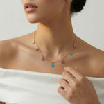 Gold chain necklace with pastel clover charms in turquoise and lilac tones, minimal elegant design for everyday wear.
