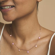 Blush pink charm drop chain necklace with delicate round pendants on a fine minimal chain