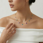 Gold chain necklace with turquoise and purple round charm drops arranged evenly across a delicate minimal design
