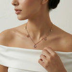 Rose gold delicate chain necklace with small dangling charms and minimal drop pendant design