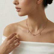 Rose gold geometric charm necklace with delicate drop accents and minimal chain design