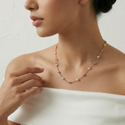 Rose gold beaded chain necklace with evenly spaced pearl accents on a minimal