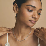 Layered blush bead chain necklace with multiple delicate chains and soft pink beads on a minimal