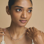 Layered blush bead chain necklace with multiple delicate chains and soft pink beads on a minimal