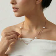 Layered pearl drop chain necklace with delicate gold chains and spaced pearl accents