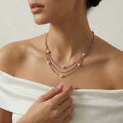 Layered multi chain pearl necklace with delicate gold toned chains and spaced pearls
