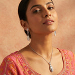 Dual tone oval drop necklace and earrings set with cutwork detailing and blush accents
