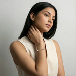 Rose gold bracelet with crystal cube charms and tassel chain design
