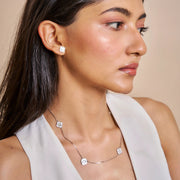 Minimal pink clover station necklace with delicate chain and evenly spaced floral charms

