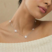 Minimal pink clover station necklace with delicate chain and evenly spaced floral charms
