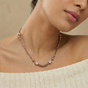 Rose gold beaded chain necklace with polished spherical accents and textured chain design
