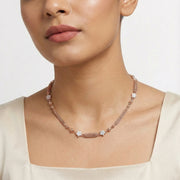 Rose gold beaded tassel necklace with polished spheres and textured chain detailing

