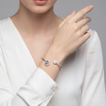 Open cuff bracelet with evil eye charm and crystal stud design in a sleek minimal style