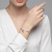 Open cuff bracelet with evil eye charm and crystal stud design in a sleek minimal style