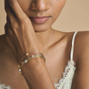 Triple tone mesh bracelet with gold silver and rose gold braided bands featuring crystal charm accents and clasp closure.