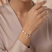 Rose gold adjustable bracelet with white heart charms and clover centerpiece