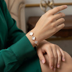 Rose gold adjustable bracelet with white clover floral charms and sleek slider chain design for women.