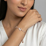Rose gold cloud charm bracelet with white enamel cloud motifs and sparkling crystal stones on a delicate chain bracelet.