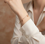 Minimal rose gold bracelet with dangling cube charms and delicate chain design for women