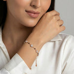 Elegant rose gold halo bracelet with crystal charms and black bead accents on a delicate chain design.