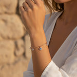 Rose gold evil eye charm bracelet with crystal accents and delicate dangling charms on a fine chain bracelet for women.