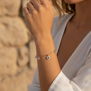 Rose gold evil eye charm bracelet with crystal accents and delicate dangling charms on a fine chain bracelet for women.