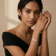 Rose gold bracelet with three sparkling circular charms and black bead chain detailing
