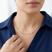 Elegant rose gold station necklace with polished bead accents on a fine minimal chain for modern everyday styling.