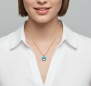 Rose gold necklace with blue geometric crystal pendant on a minimal chain design.
